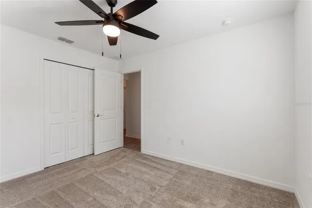 an empty room with a ceiling fan and a ceiling fan