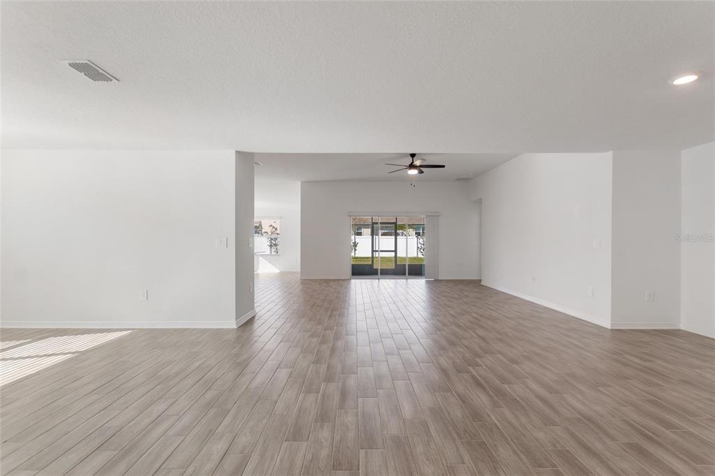 5767 Talc St Mount Mount Dora, FL 32757 - Photo 10 of 44 an empty room with wooden floor and windows