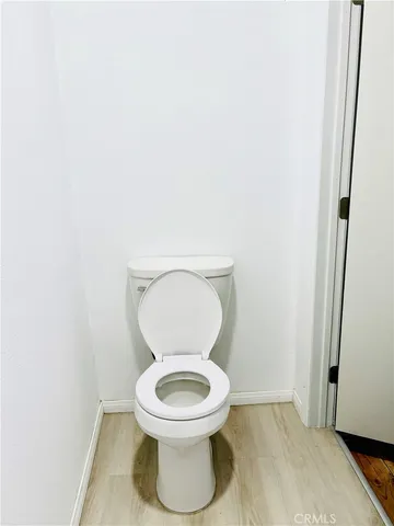 a white toilet sitting next to a white wall