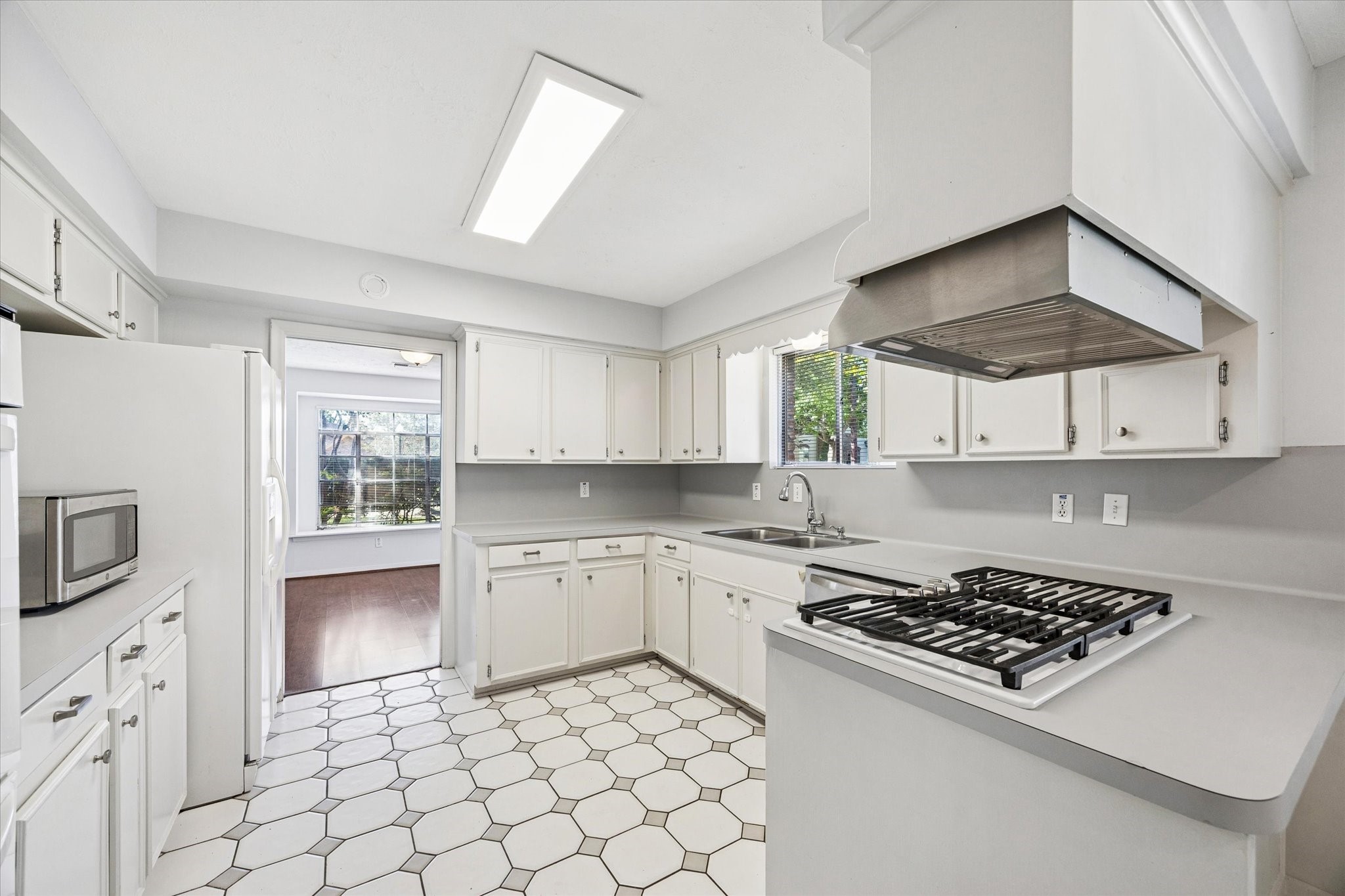 8730 Cedarspur Drive Houston, TX 77055 - Photo 12 of 23 a kitchen with white cabinets a sink stove and wooden floor