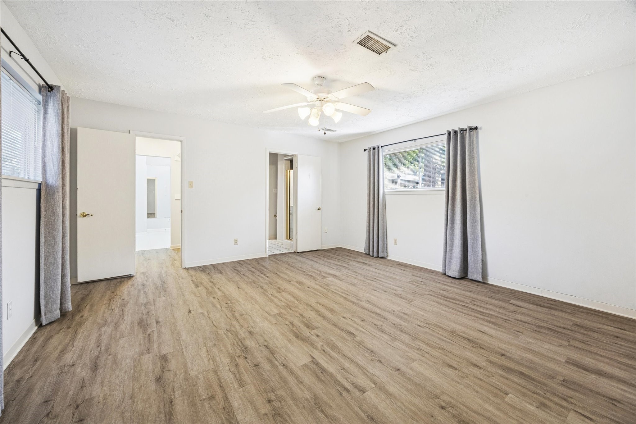 8730 Cedarspur Drive Houston, TX 77055 - Photo 16 of 23 a view of an empty room with wooden floor and a ceiling fan