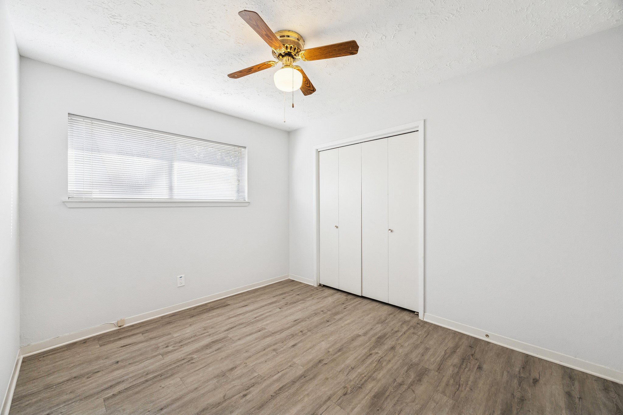 8730 Cedarspur Drive Houston, TX 77055 - Photo 17 of 23 an empty room with wooden floor and ceiling fan