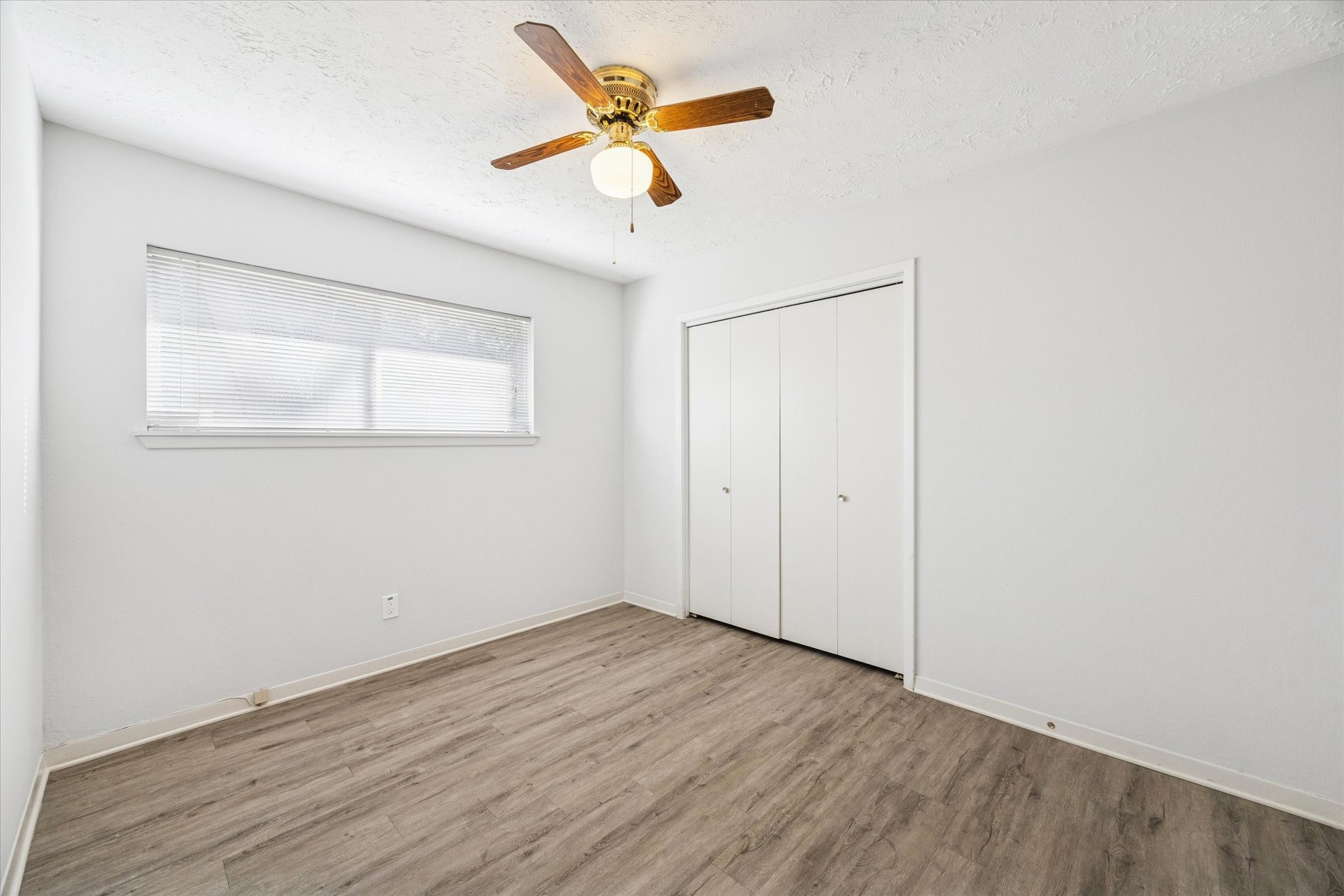 8730 Cedarspur Drive Houston, TX 77055 - Photo 18 of 23 an empty room with wooden floor and ceiling fan