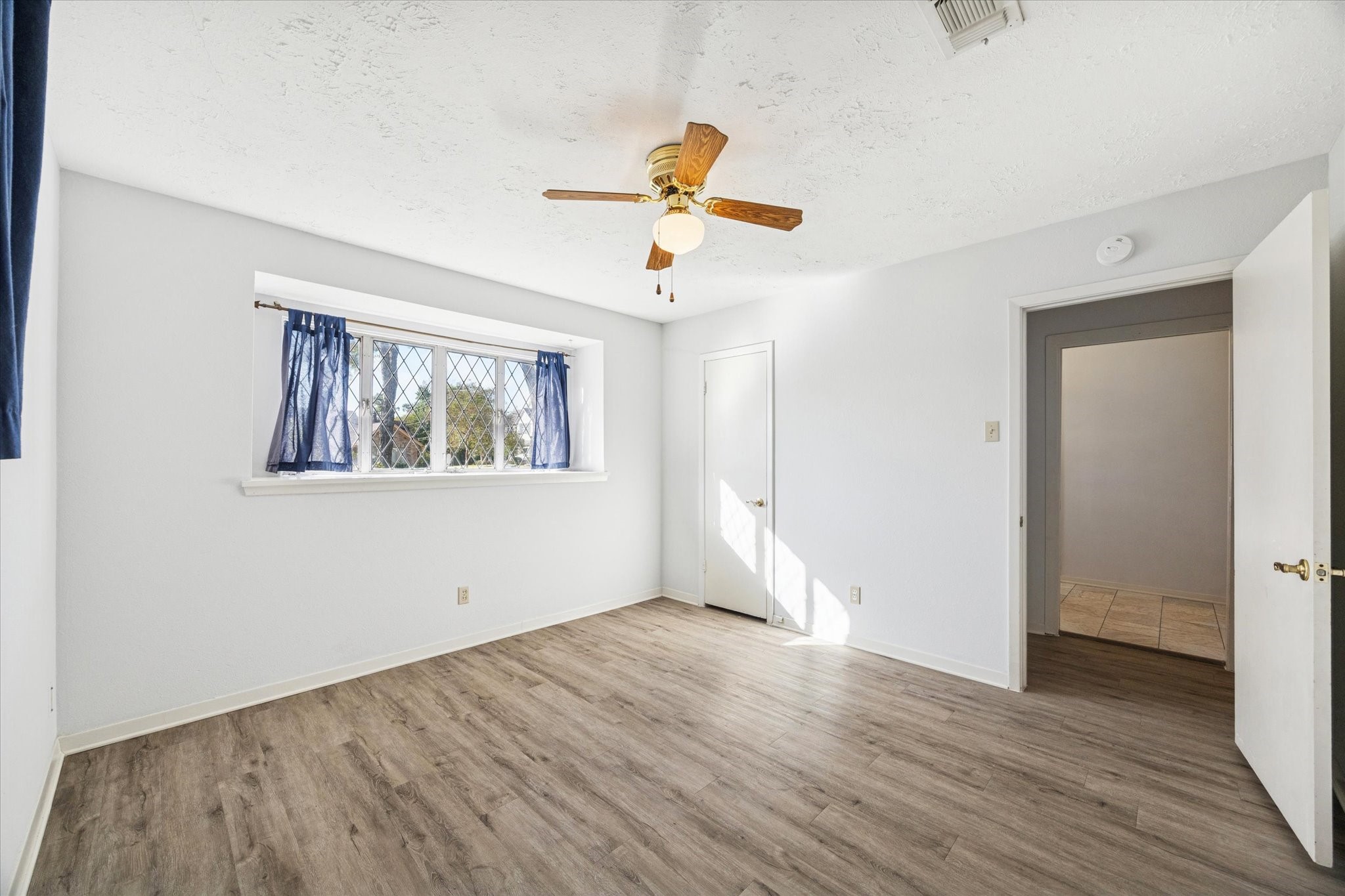 8730 Cedarspur Drive Houston, TX 77055 - Photo 19 of 23 an empty room with wooden floor ceiling fan and windows