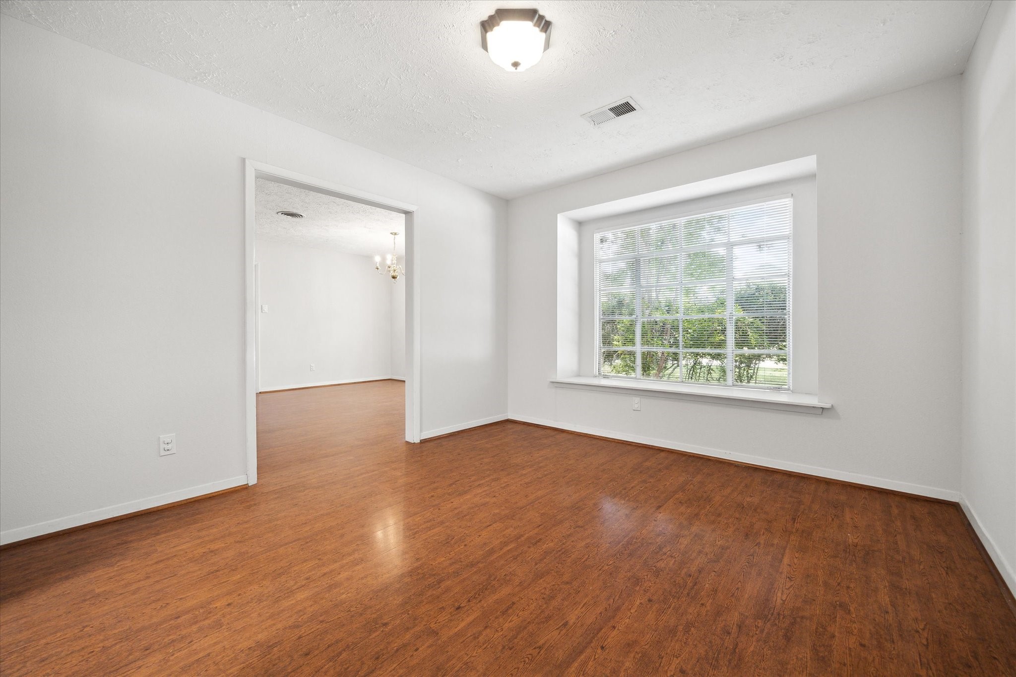 8730 Cedarspur Drive Houston, TX 77055 - Photo 6 of 23 an empty room with wooden floor and windows