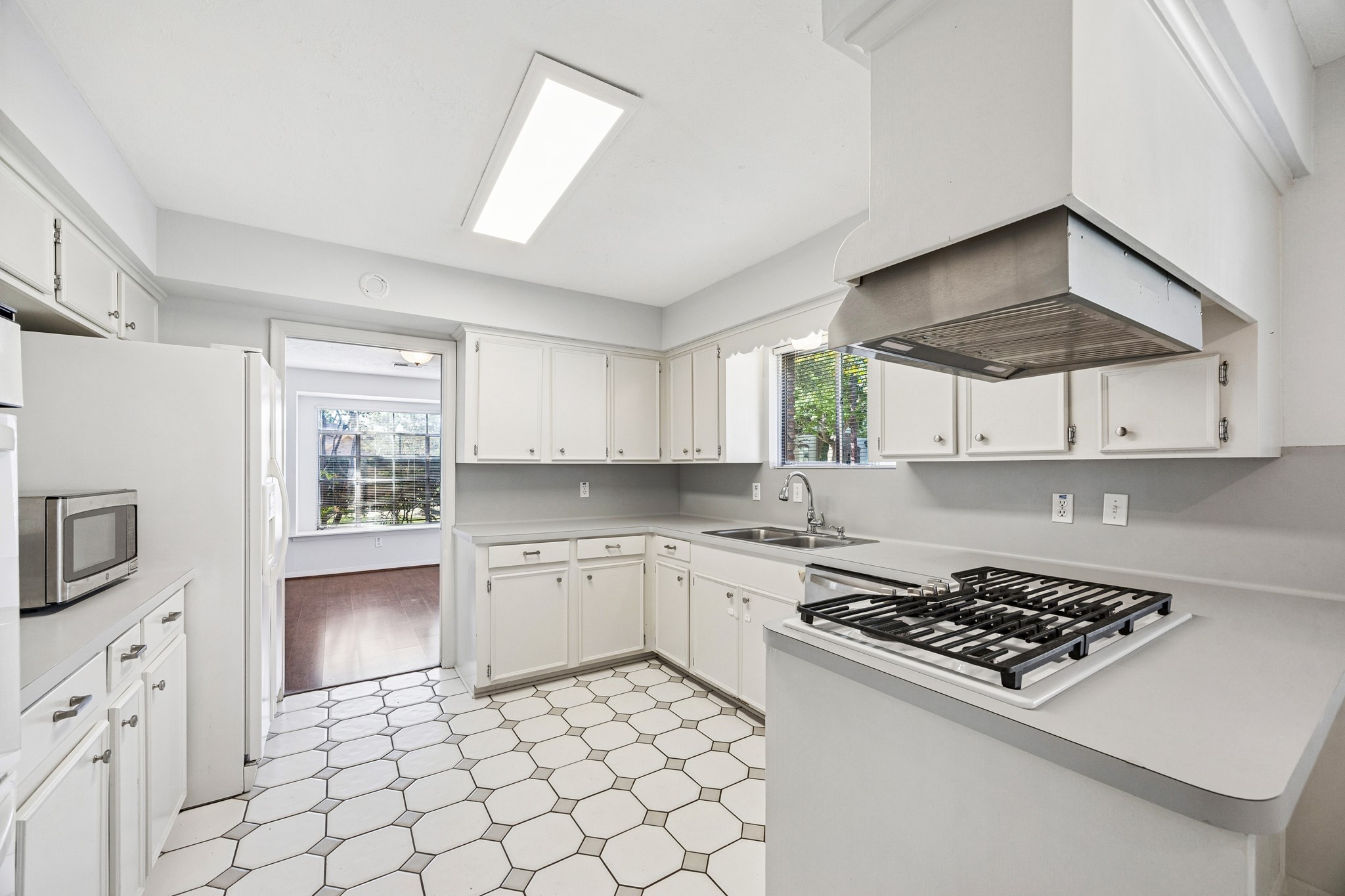 8730 Cedarspur Drive Houston, TX 77055 - Photo 10 of 23 a kitchen with white cabinets a sink stove and wooden floor