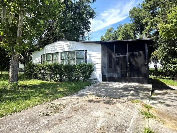a front view of a house with a yard and tree