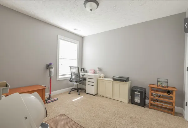 a view of a workspace with furniture and a window