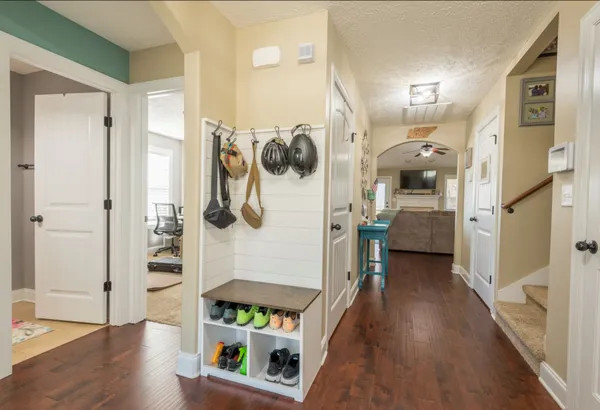 a hallway with white cabinets and wooden floor