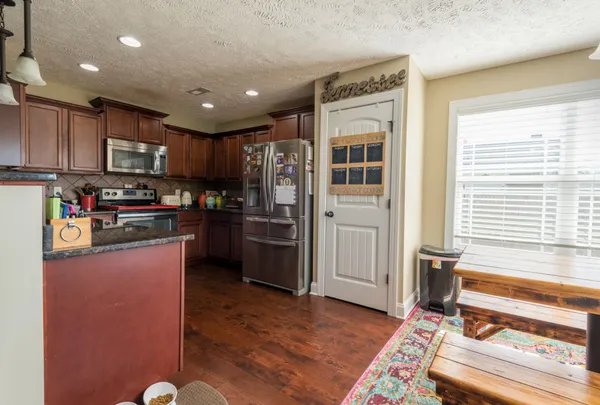 a kitchen with stainless steel appliances granite countertop a refrigerator stove and sink