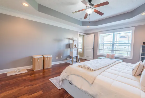 a spacious bedroom with a bed and a chandelier