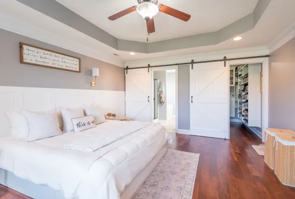 a spacious bedroom with a bed and a chandelier