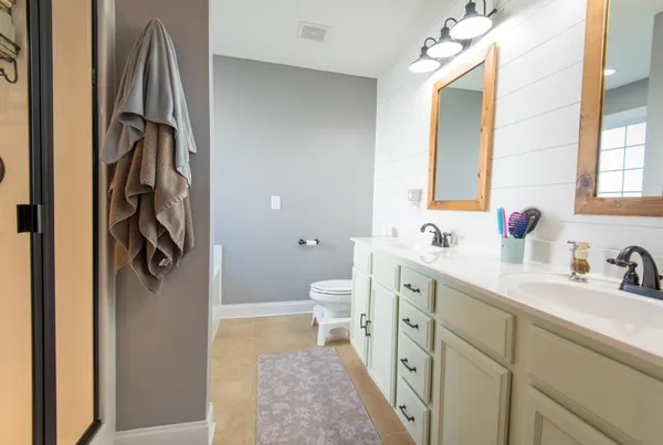 a bathroom with a sink a toilet and a mirror