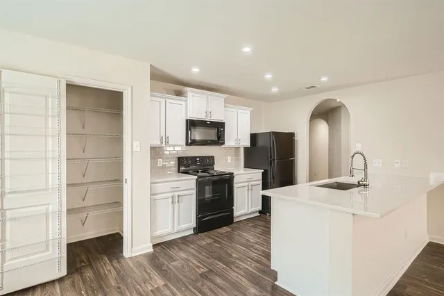 a kitchen with sink a microwave and refrigerator