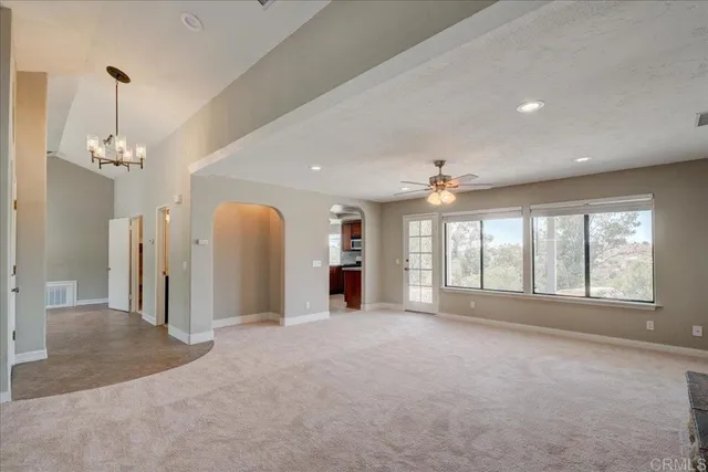 a kitchen with stainless steel appliances granite countertop a refrigerator a sink dishwasher a stove and white countertops with wooden floor