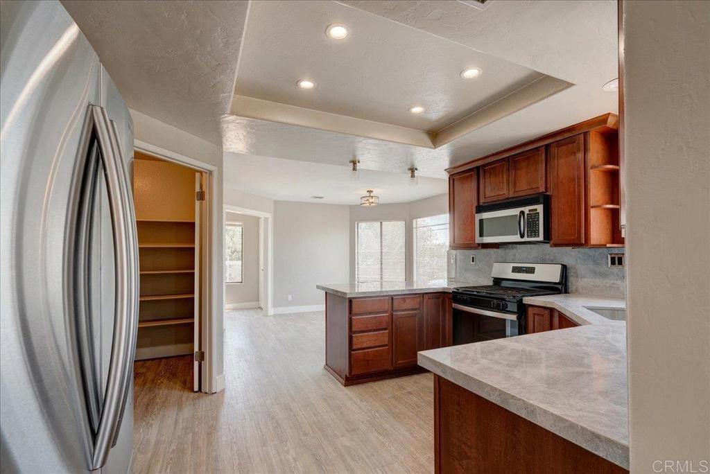 18434 Ramona View Drive Ramona, CA 92065 - Photo 19 of 72 a kitchen with stainless steel appliances granite countertop a refrigerator a stove a sink and a microwave