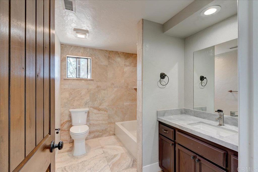18434 Ramona View Drive Ramona, CA 92065 - Photo 36 of 72 a bathroom with a granite countertop sink a toilet and shower