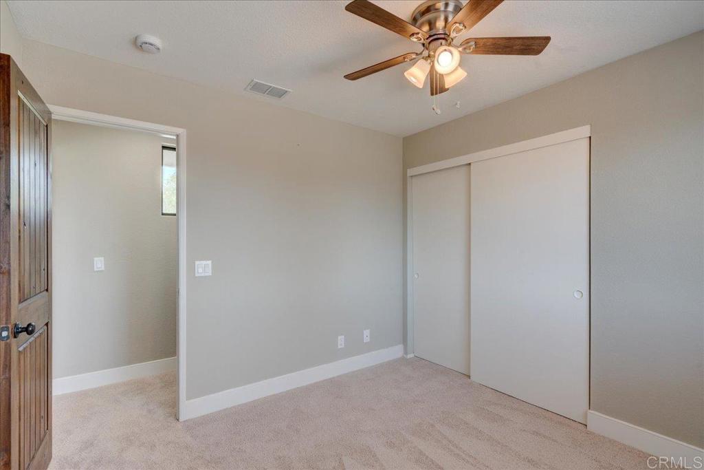 18434 Ramona View Drive Ramona, CA 92065 - Photo 39 of 72 an empty room with closet and a chandelier fan
