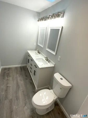 a bathroom with a toilet sink and mirror