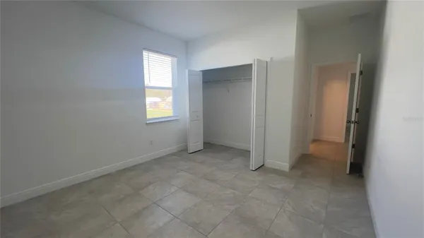 an empty room with windows and closet