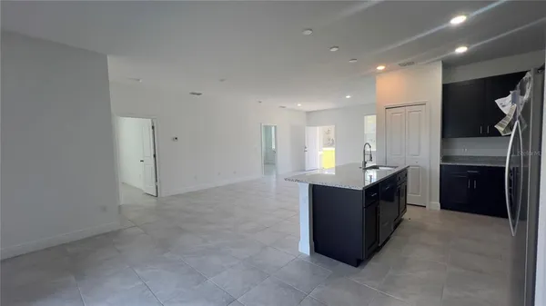 a kitchen with stainless steel appliances kitchen island granite countertop a refrigerator and a sink