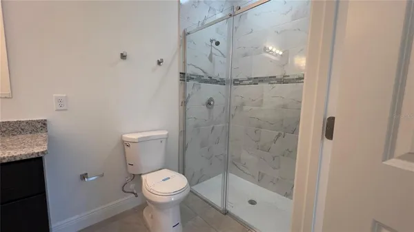 a bathroom with a granite countertop sink a toilet and a mirror