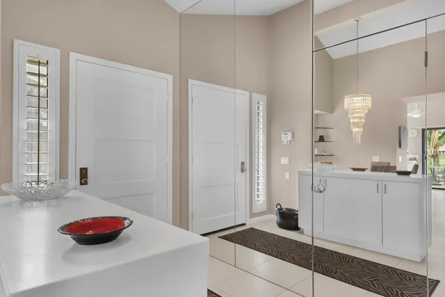 a living room with couches a flat screen tv and kitchen view