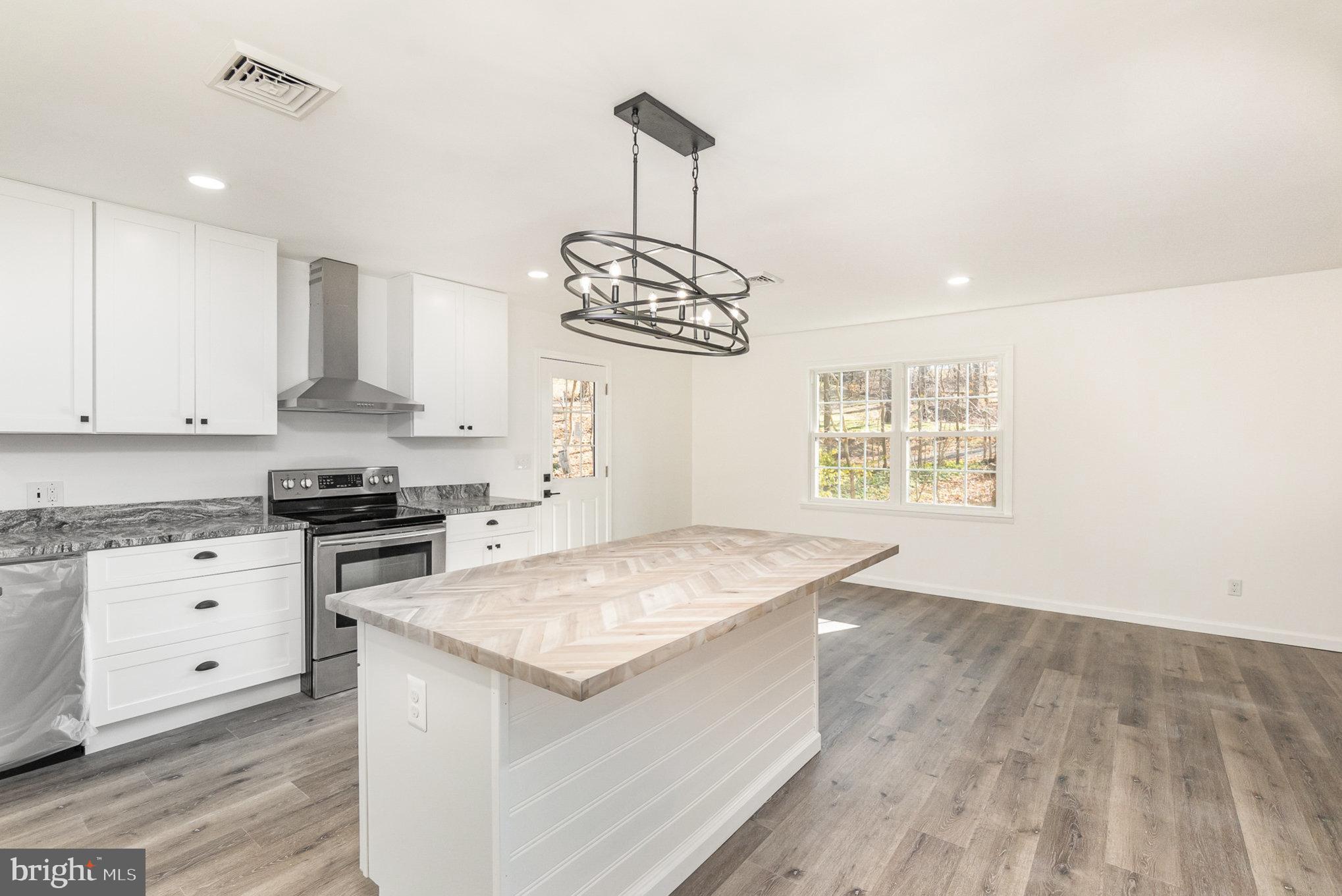 5505 Williams Road Hydes, MD 21082 - Photo 12 of 42 a kitchen with stainless steel appliances granite countertop a stove a sink and a microwave
