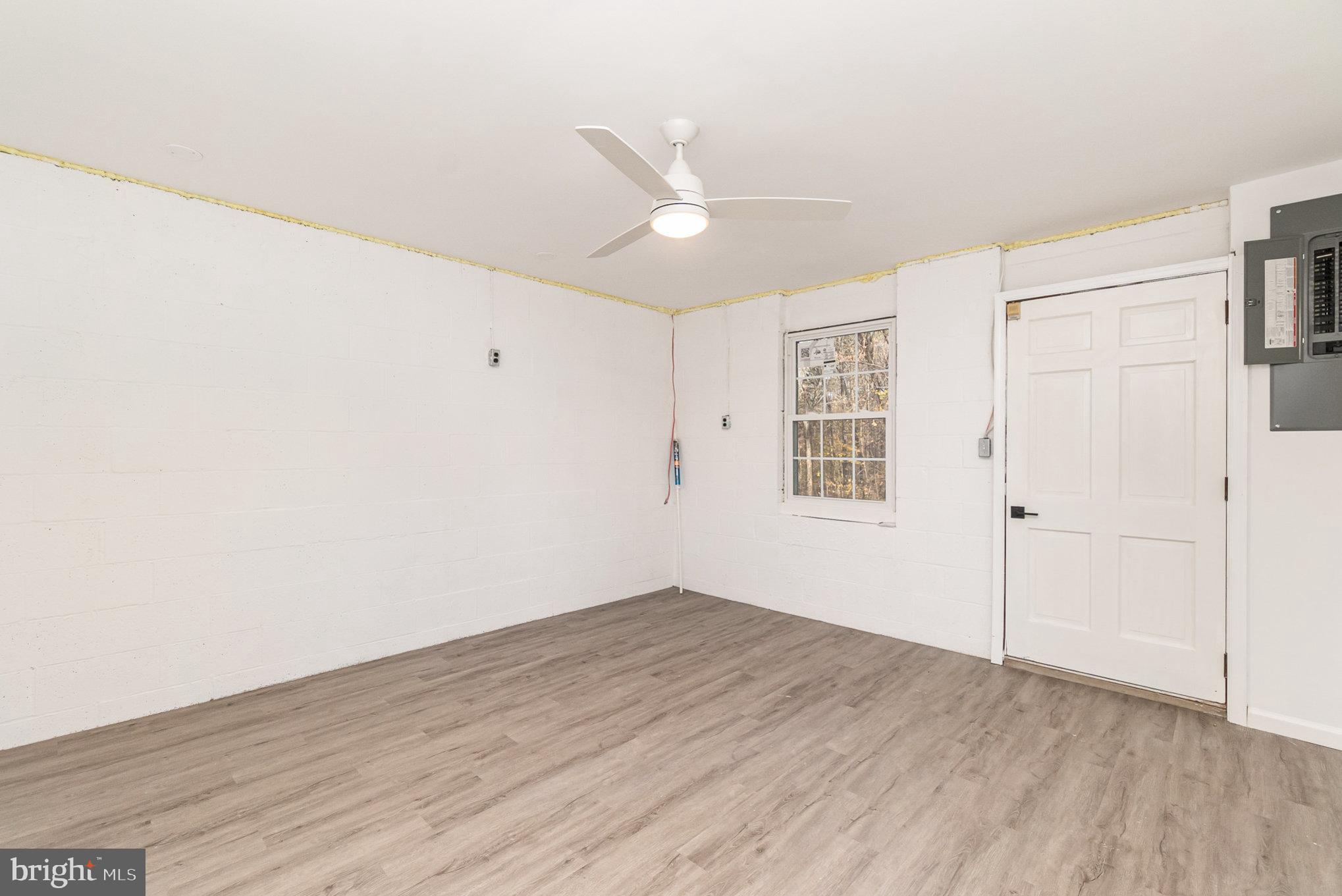 5505 Williams Road Hydes, MD 21082 - Photo 24 of 42 an empty room with wooden floor ceiling fan and windows