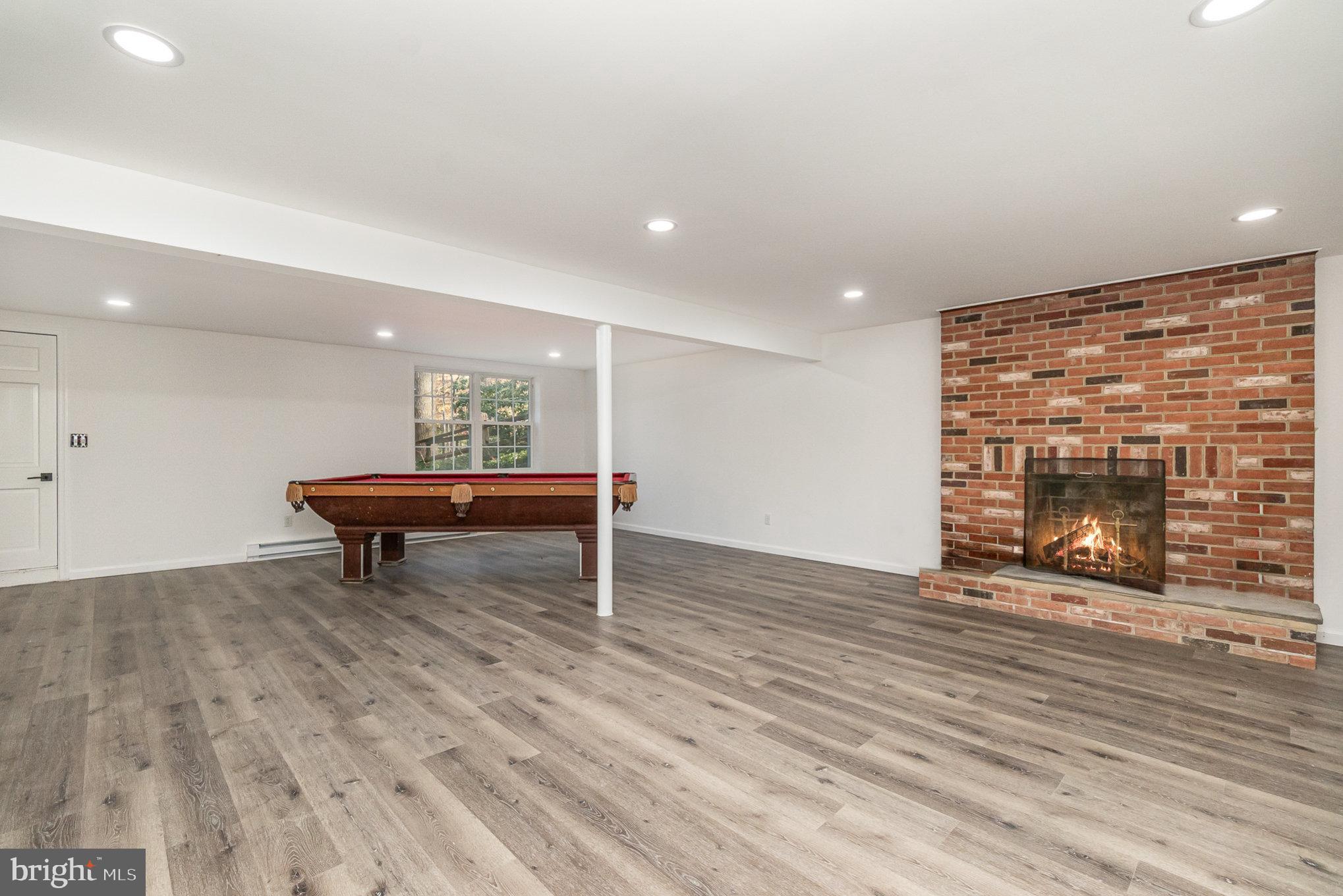 5505 Williams Road Hydes, MD 21082 - Photo 31 of 42 an empty room with wooden floor a fireplace and windows