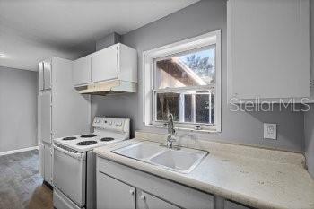 1533 North Normandy Boulevard Deltona, FL 32725 - Photo 7 of 15 a kitchen with granite countertop a sink stove and cabinets