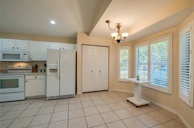 a kitchen with white cabinets and window