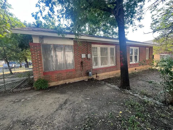 a view of a house with a yard and large tree
