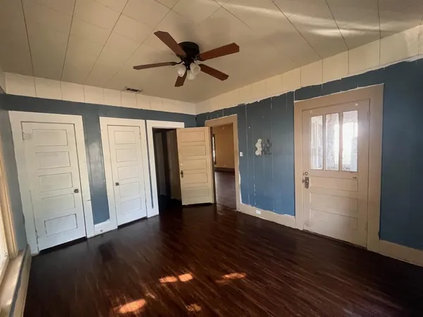 a view of a livingroom with wooden floor and a ceiling fan
