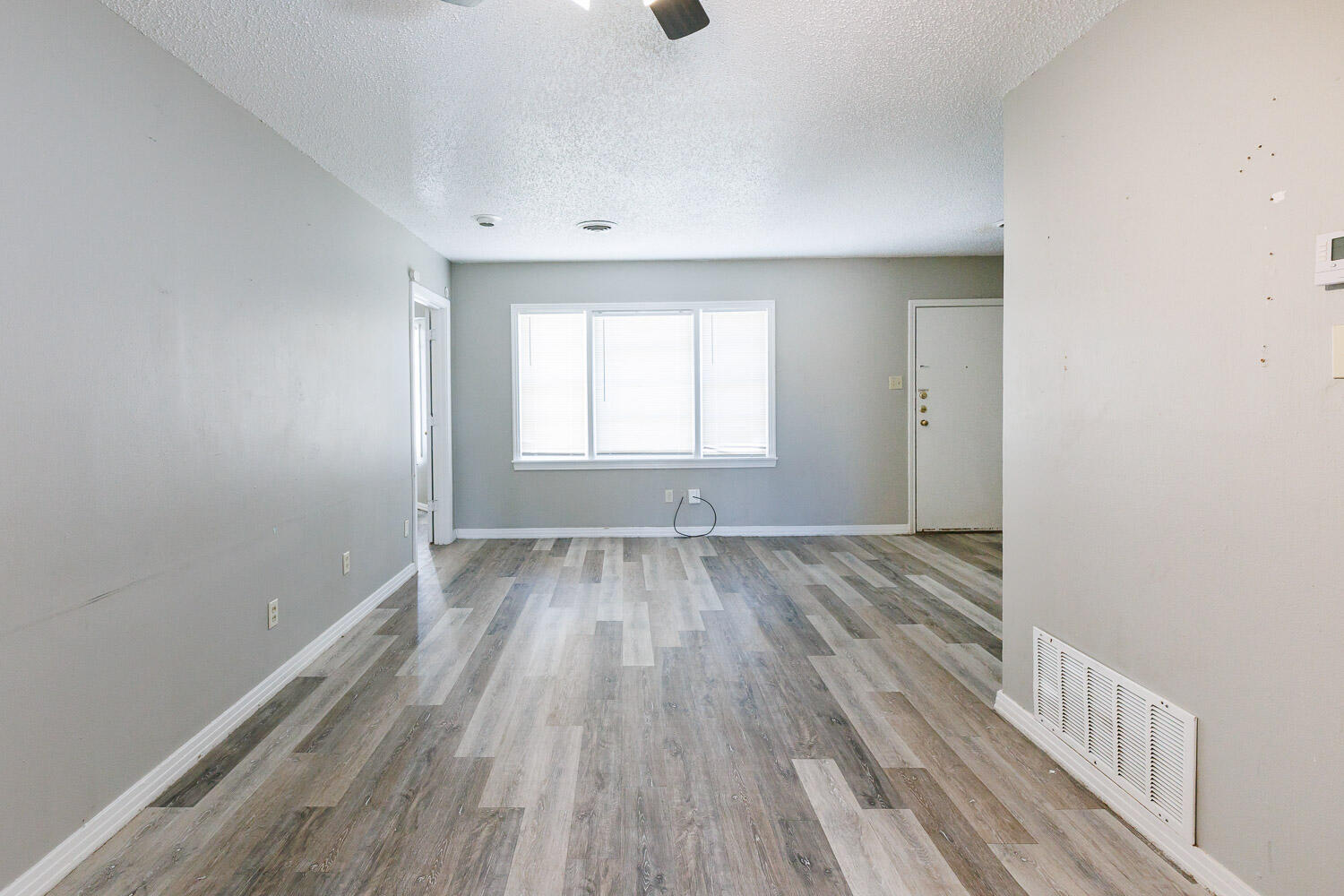 2417 37th Street Lubbock, TX 79412 - Photo 10 of 35 an empty room with wooden floor and windows