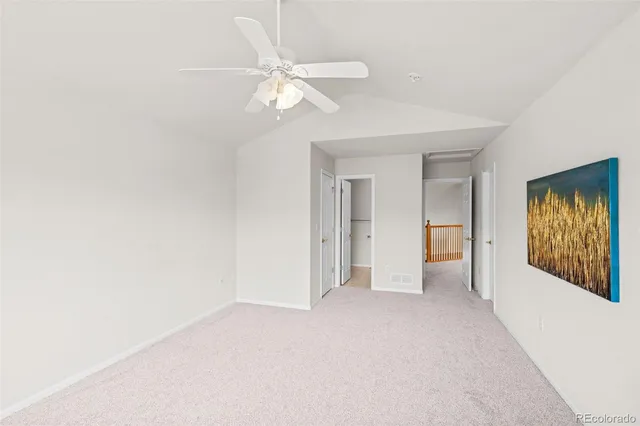 an empty room with a chandelier fan and closet area