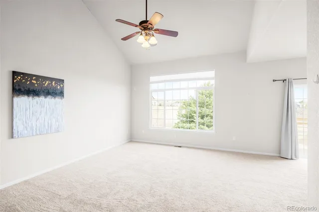 an empty room with a window and a fan