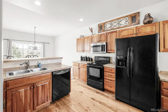 a kitchen with stainless steel appliances granite countertop a stove refrigerator sink and dishwasher