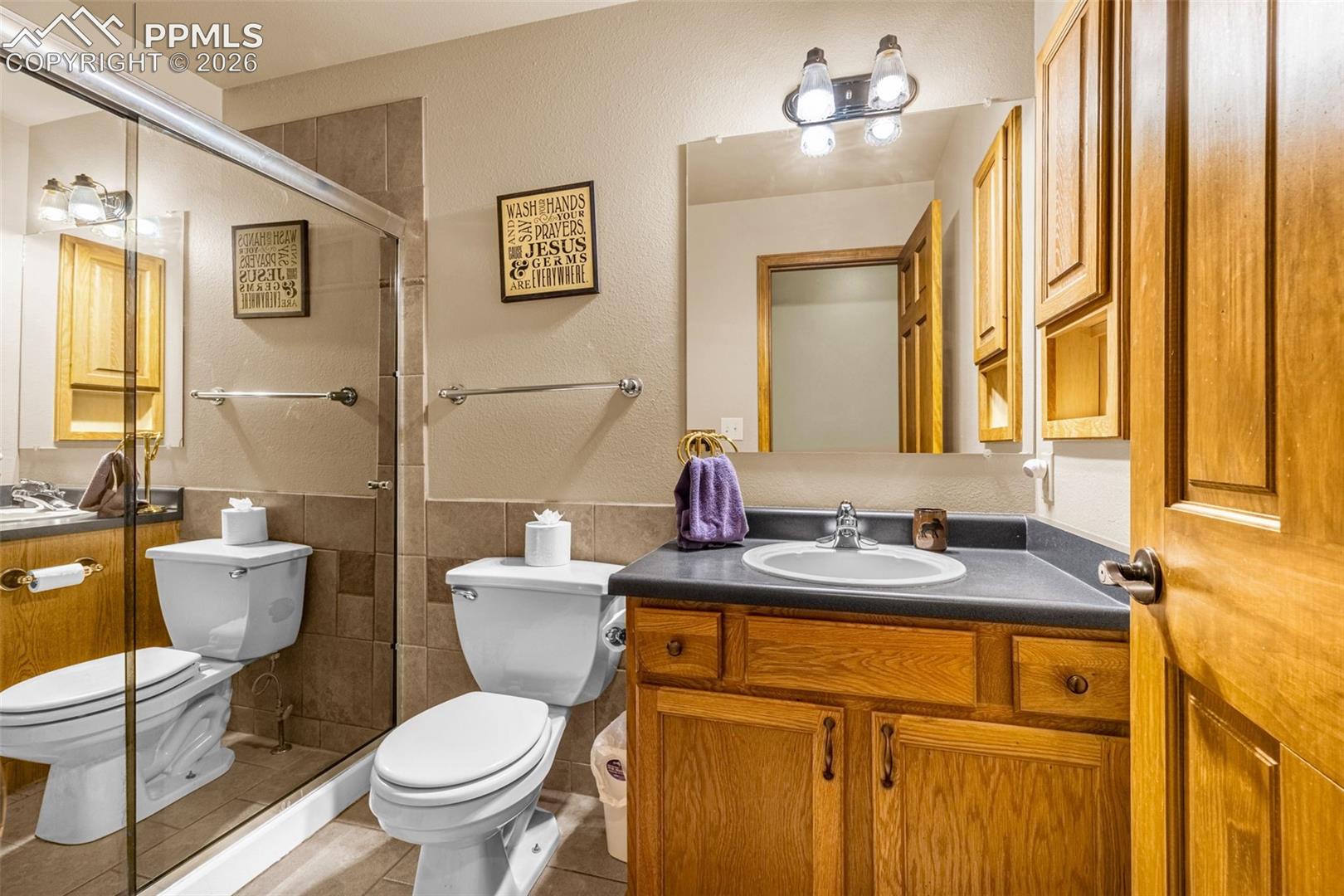 143 Ring Road Guffey, CO 80820 - Photo 22 of 36 Full bathroom featuring tile walls, tile patterned flooring, vanity, a tile shower, and wainscoting