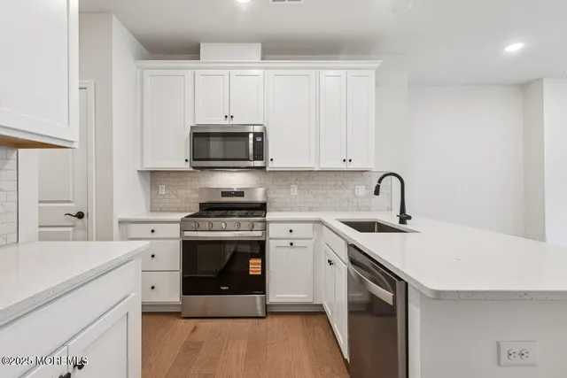 a kitchen with stainless steel appliances granite countertop a stove and a sink