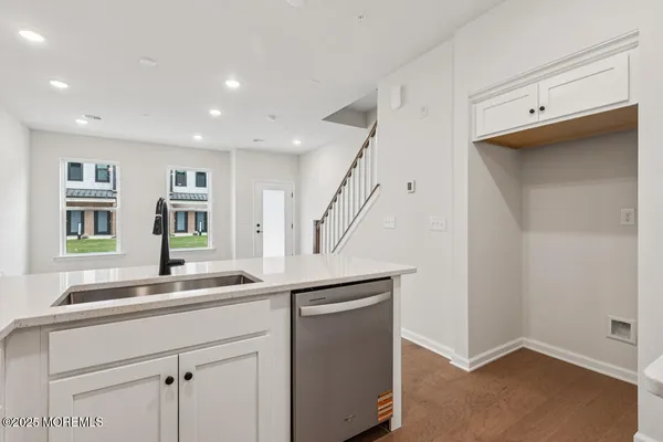 a kitchen with a sink and wooden floor
