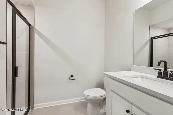 a bathroom with a sink a toilet a mirror and shower