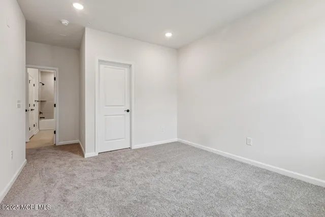 an empty room with mirror and closet area