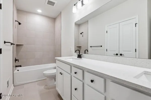 a bathroom with a double vanity sink toilet mirror and shower
