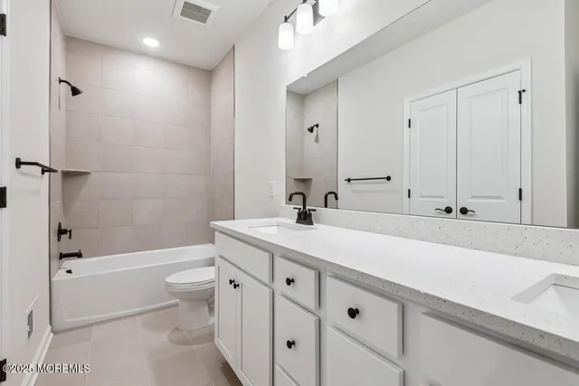a bathroom with a double vanity sink toilet mirror and shower