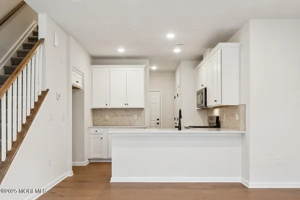 a large white kitchen with kitchen island a sink stainless steel appliances and cabinets