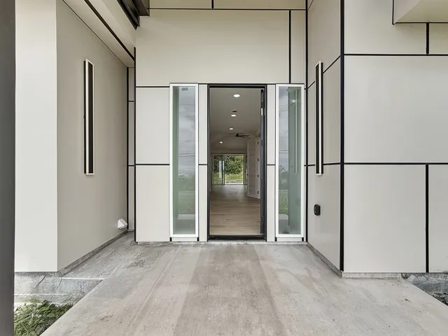 a view of a refrigerator in kitchen and an empty room