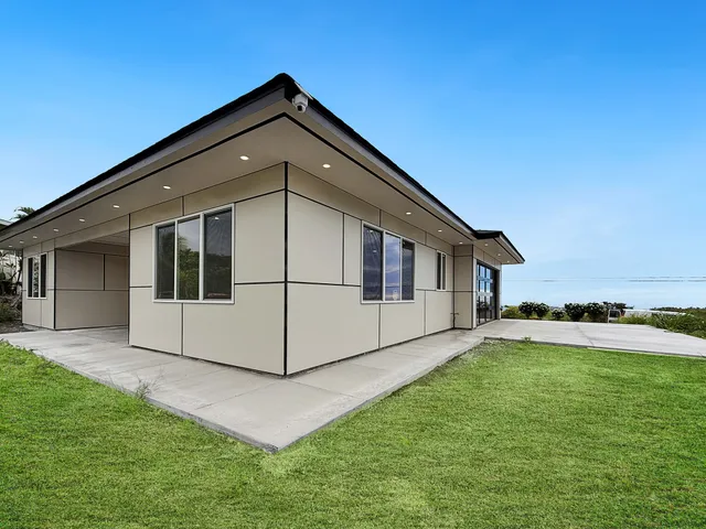 a white house that has a big yard in front of it