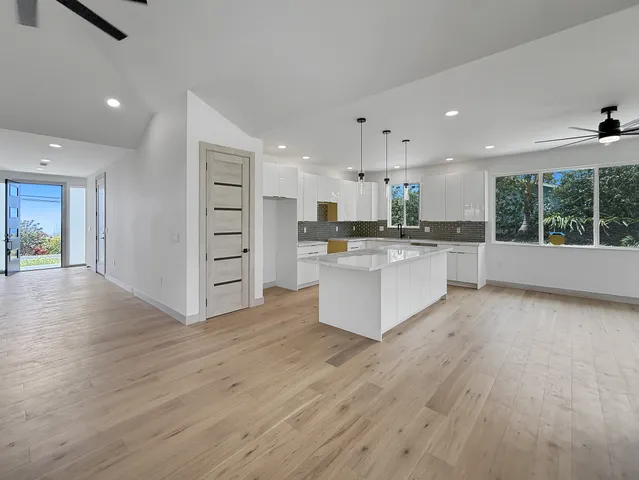 a large kitchen with stainless steel appliances kitchen island a large counter top and a sink