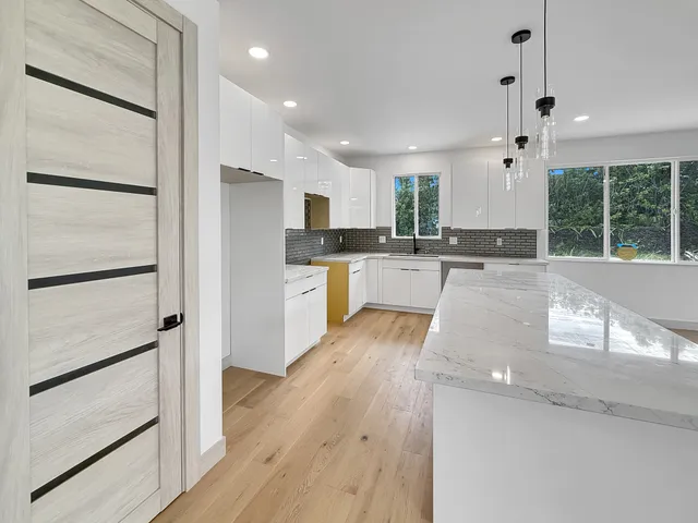 a large kitchen with kitchen island a large window
